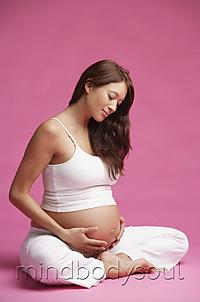 Mind Body Soul - Pregnant woman sitting in half-lotus, hands on stomach