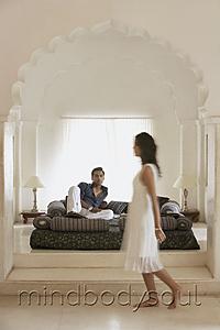 Mind Body Soul - Couple in white room, woman walking by bed
