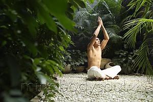 Mind Body Soul - man practicing yoga surrounded by plants