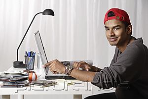 PictureIndia - young man with red cap working on laptop
