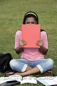 PictureIndia - young woman laughing behind folder