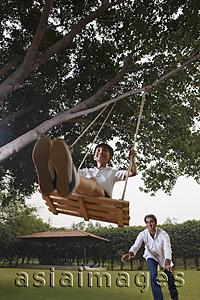 Asia Images Group - father pushing son in swing