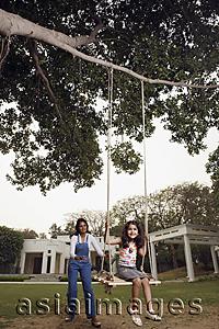 Asia Images Group - mother pushing daughter in swing