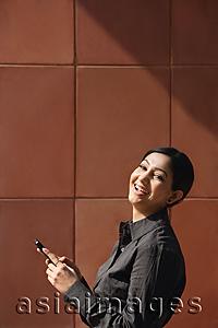 Asia Images Group - woman holding mobile phone, laughing