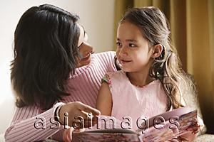 Asia Images Group - mother looks at daughter sitting on her lap