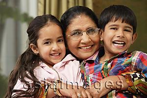 Asia Images Group - grandmother hugs grandkids, all smile at camera