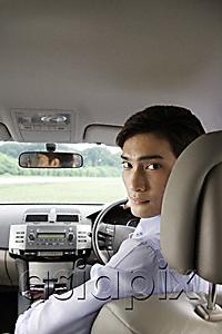 AsiaPix - Man driving car, looking back over shoulder