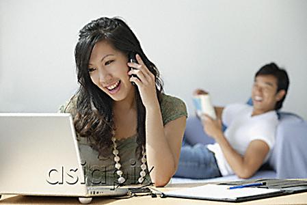 AsiaPix - Young woman at computer, young man on couch