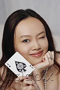 AsiaPix - Young woman holding ace of spades card