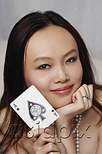 AsiaPix - Young woman holding ace of spades card