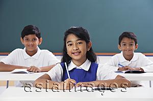 Asia Images Group - three students smile at camera, girl in center