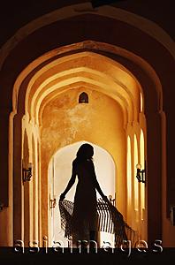 Asia Images Group - silhouette of woman in arched hallway
