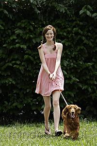 Mind Body Soul - Young woman being pulled by dog on leash