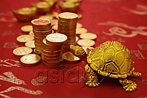 AsiaPix - Still life of gold tortoise figurine and gold coins