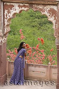 Asia Images Group - young woman at balcony, smiling