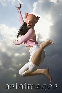 Asia Images Group - young lady with pig mask, jumping high