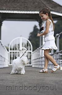 Mind Body Soul - young girl walking white dog on leash