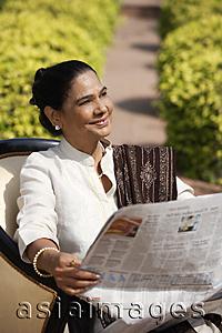 Asia Images Group - woman reading newspaper
