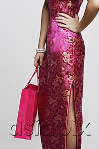 AsiaPix - Cropped shot of woman wearing a pink cheongsam holding a shopping bag
