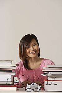 AsiaPix - Young woman sitting at desk with books.