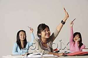 AsiaPix - Three women raising their hands in class.