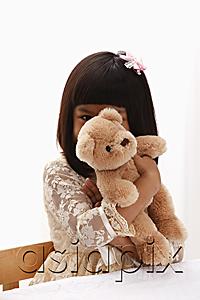 AsiaPix - young girl holding teddy bear in front of her face