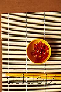 AsiaPix - Small bowl of red chillies and chopsticks.