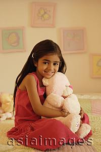 Asia Images Group - little girl on bed with teddy bear