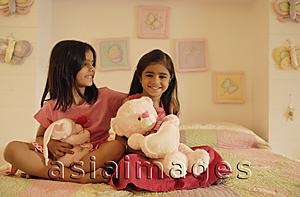 Asia Images Group - little girls with stuff bears on bed