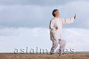 Asia Images Group - Older woman doing tai chi.