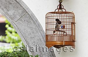 Asia Images Group - Wicker bird cage hanging on wall