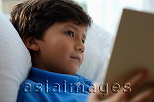 Asia Images Group - Head shot of young boy reading book