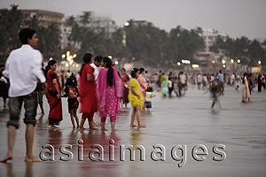 Asia Images Group - A crowd of people walking along the beach in Mumbai, India