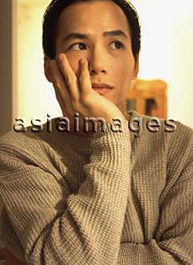 Asia Images Group - Man with thoughtful expression, resting head on hand