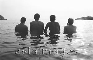 Asia Images Group - Teenagers wading in ocean, rear view, silhouette