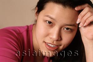 Asia Images Group - Young woman with head on hand, smiling, portrait