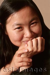 Asia Images Group - Young woman with hands on chin smiling, portrait