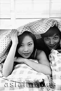 Asia Images Group - Man and woman in bed under sheet, portrait