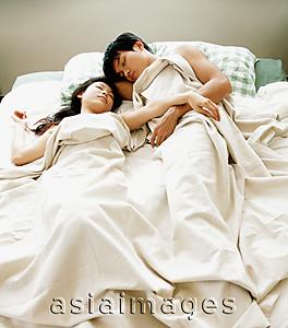 Asia Images Group - Man and woman in bed, under sheet