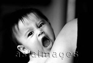 Asia Images Group - Baby yawning in arms of mother