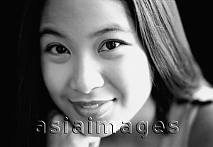 Asia Images Group - Young woman with hand on chin, smiling.