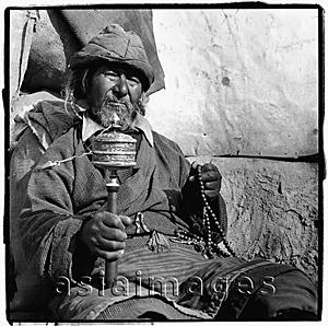 Asia Images Group - India, Ladakh, Leh, Portrait of Tibetan man holding prayer wheel and prayer beads.