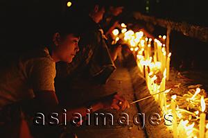 Asia Images Group - Myanmar (Burma), Kyaiktiyo, Buddhist pilgrims lighting candles at 'golden rock'.