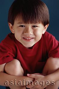 Asia Images Group - Young boy sitting with arms around his knees