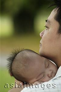 Asia Images Group - Father carrying sleeping baby, over the shoulder view.
