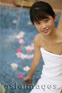 Asia Images Group - Young woman sitting by pool