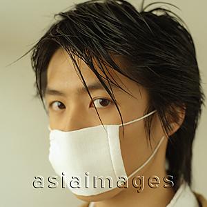 Asia Images Group - Man with a face mask, portrait