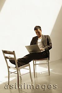 Asia Images Group - Man sitting down, using laptop