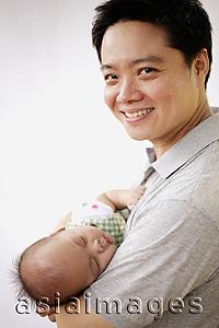 Asia Images Group - Father carrying infant son