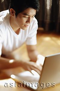 Asia Images Group - Young man using laptop.